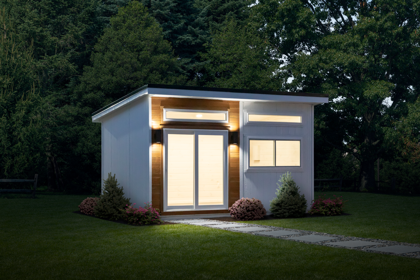  A small house situated in the center of a grassy yard, surrounded by open space and greenery.