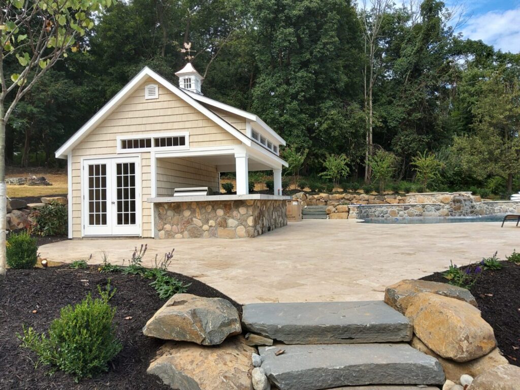A backyard featuring a swimming pool surrounded by greenery and a gazebo for relaxation.