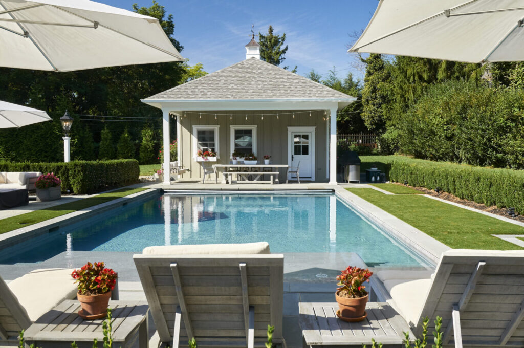 A serene pool area featuring lounge chairs and umbrellas for relaxation under the sun.