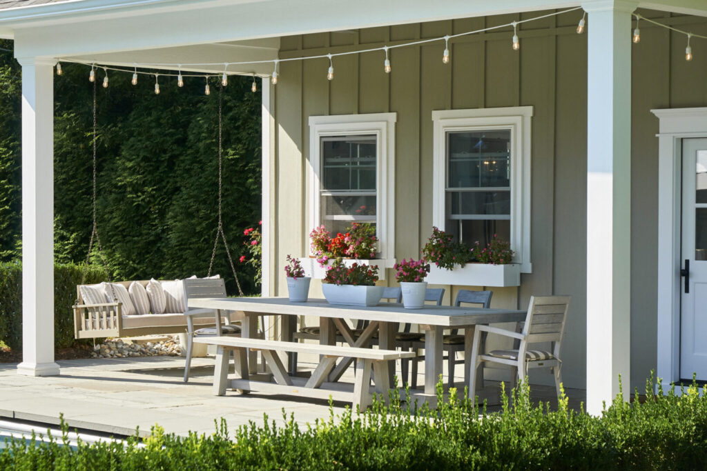 An outdoor patio with a table and several chairs, perfect for gatherings and enjoying fresh air.