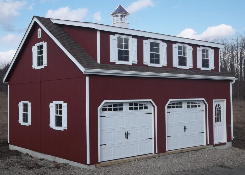 A red barn with two garages, featuring white trim around the doors and windows.