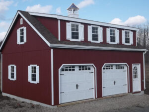 A red barn with two garages, featuring white trim around the doors and windows.