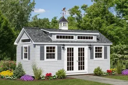 A compact white shed with a roof and two windows, set against a neutral background.