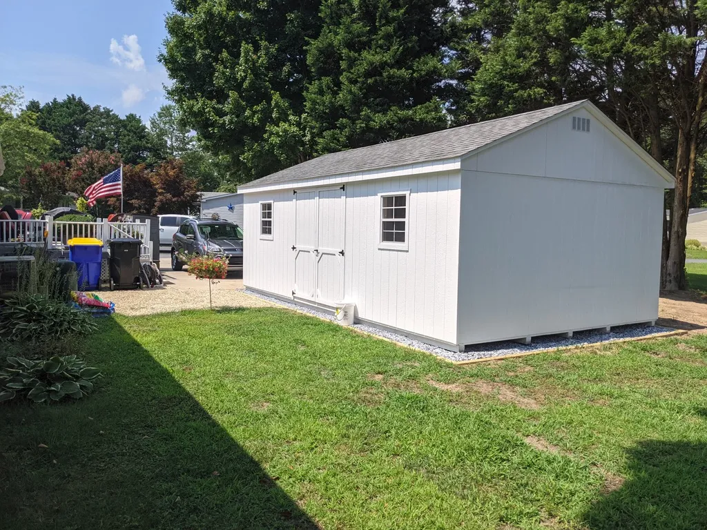 A shed featuring a white door and a flag displayed on its side.